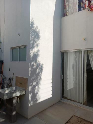 a shadow of a tree on the side of a building at Excelente hogar para descansar in Gómez