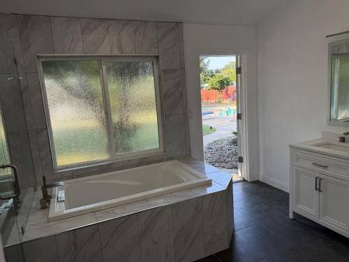 a large bath tub in a bathroom with a window at New Unique Home Near Airport in Fresno