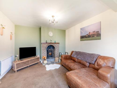 a living room with a couch and a fireplace at Adderstone Folly in Belford