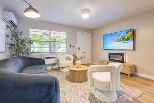 a living room with a couch and chairs and a tv at Biva Luxe in West Palm Beach