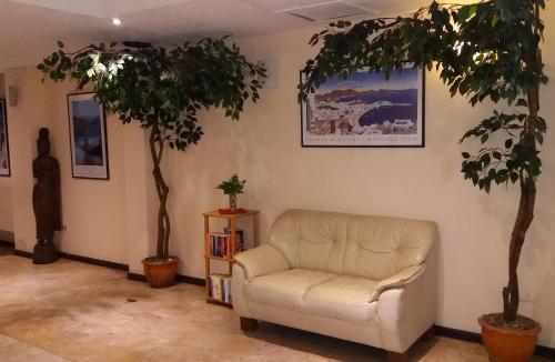 a living room with a couch and two trees at Paradise Inn in Karon Beach