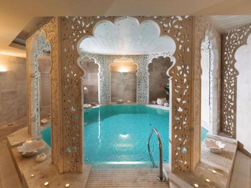 a swimming pool in a room with a building with a ceiling at Mercure Palanga Vanagupe Resort & SPA in Palanga