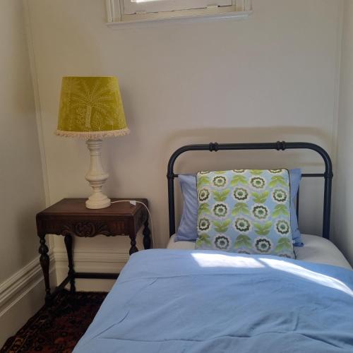 a bedroom with a bed and a lamp on a table at Miss Victoria in Nerrina