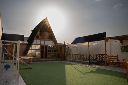 a house with a playground in front of it at اكواخ روزڤيو الفندقيه Roseview Cottages in Taif