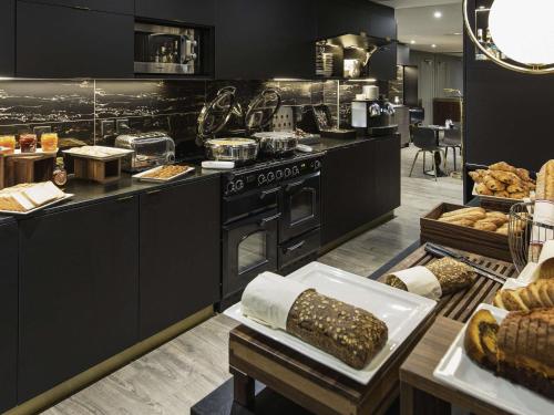 a kitchen with a stove and a bunch of bread at Mercure Nancy Centre Place Stanislas in Nancy