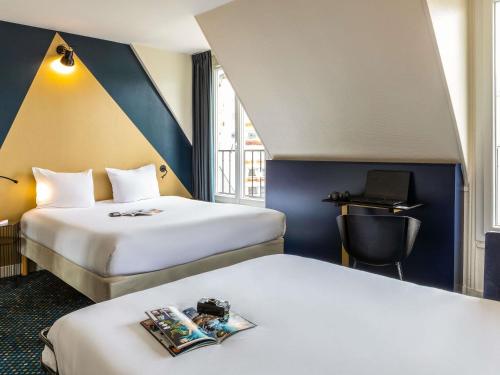 Una habitación de hotel con dos camas y un escritorio. en ibis Styles Paris 15 Lecourbe, en París