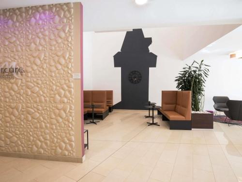 a lobby with a wall with a clock in the background at Hotel Mercure Graz City in Graz