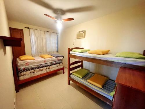 Zimmer mit 2 Etagenbetten und einer Decke in der Unterkunft Apartamento 2 Quadras da Praia da Enseada in Guarujá