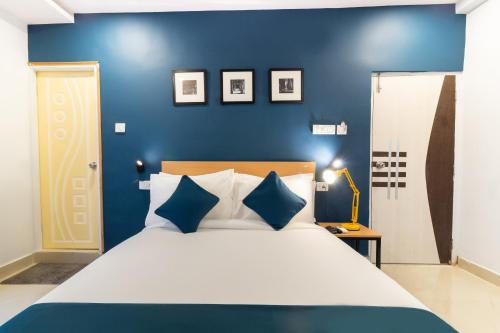 um quarto com uma cama grande e paredes azuis em THE STROBE SILVERKEY HOTEL em Hyderabad