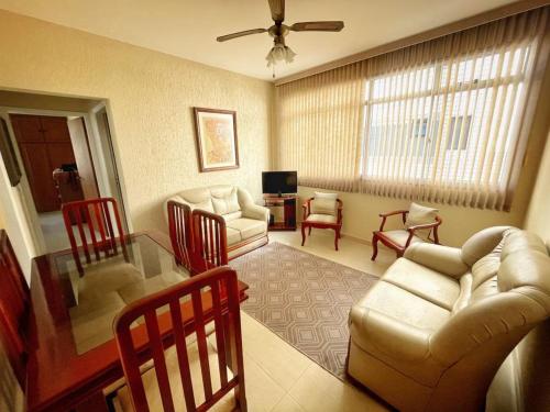 ein Wohnzimmer mit Sofa, Stühlen und einem Tisch in der Unterkunft Apartamento 2 Quadras da Praia da Enseada in Guarujá