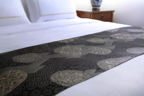 a bed with a black and white comforter on it at Hotel Chinzanso Tokyo in Tokyo