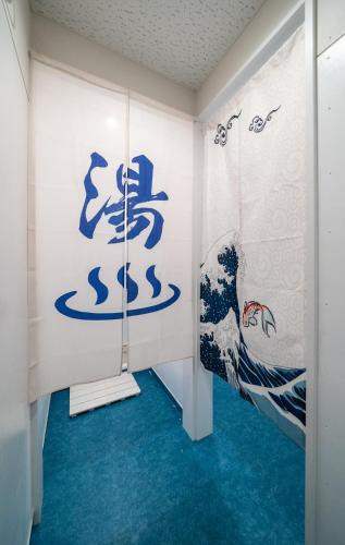 a room with a painting of a wave on the wall at エイチビーイン in Hiroshima