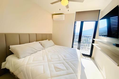 a bedroom with a white bed and a window at Luxury aprt in front of Fundidora Park, gym, BBQ. in Monterrey