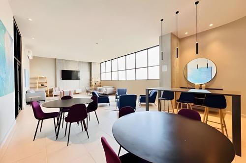a room with tables and chairs and a living room at Luxury aprt in front of Fundidora Park, gym, BBQ. in Monterrey