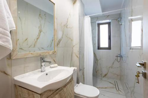 a bathroom with a sink and a shower and a toilet at Astir Apartments Kalamata in Kalamata