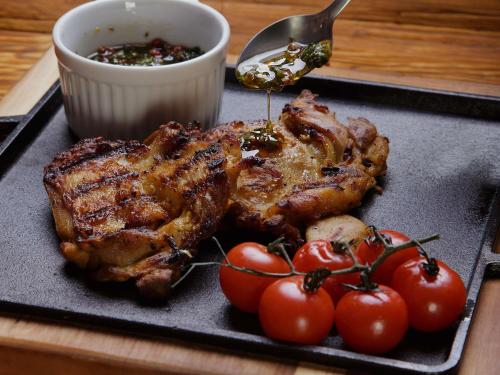 a plate of food with meat and tomatoes on a table at Novotel Sao Jose dos Campos in São José dos Campos