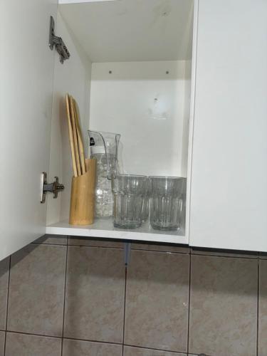 un estante de cocina con tazones y utensilios. en Cabañas Angeles, en Punta Arenas