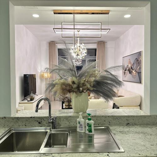 cocina con fregadero y jarrón con planta en Bellevue Towers Luxurious Burj Khalifa, Full Downtown & Old-town Views, en Dubái