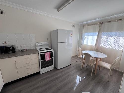 a kitchen with a white refrigerator and a table at Apartments on Turf Unit 3 in Grafton