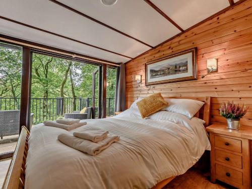 グラスミアにある2 Bed in Ambleside 75731の木製の壁に大きなベッドが備わるベッドルーム1室