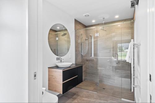 a bathroom with a sink and a shower with a mirror at 10 William Jones Place in Hanmer Springs