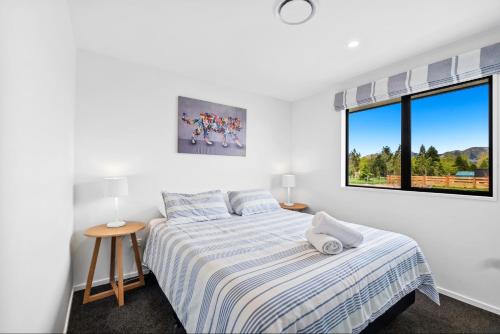 a white bedroom with a bed and a window at 10 William Jones Place in Hanmer Springs