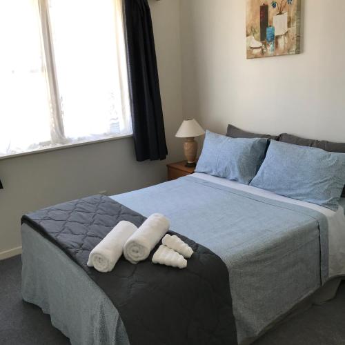 a bedroom with a bed with towels on it at The Bivvy at Hutt Central in Lower Hutt