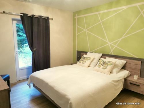 a bedroom with a large white bed with pillows at Gîte de charme à Thiel-sur-Acolin : terrasse, grand terrain, barbecue et équipements modernes - FR-1-489-338 in Thiel-sur-Acolin