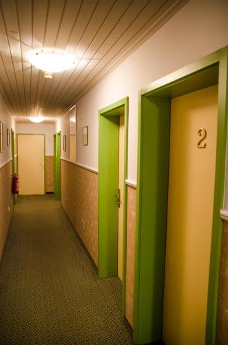 an empty hallway with green and yellow doors at Penzion Park in Laško