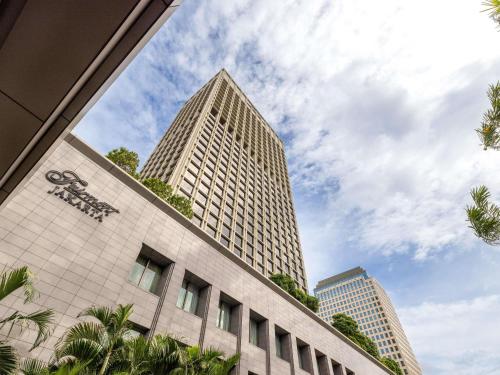 a tall building with two skyscrapers in the background at Fairmont Jakarta in Jakarta