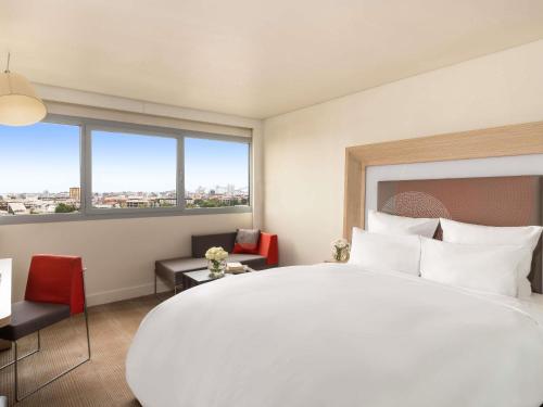 a hotel room with a large bed and a large window at Novotel Abidjan Plateau in Abidjan