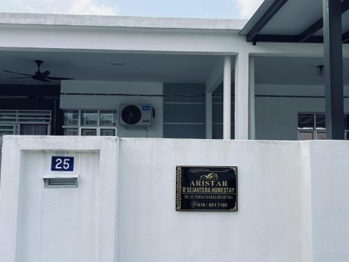 a sign on a white fence in front of a house at Aristar D'Sejahtera Homestay 4 mu5lim in Bandar  Pusat Jengka