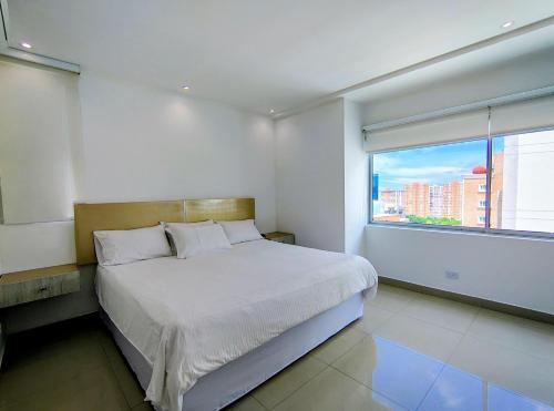 a bedroom with a bed and a large window at Apartamentos Amoblados- Buenavista Barranquilla in Barranquilla