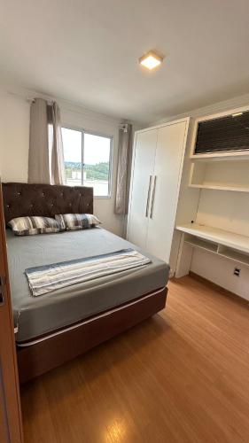 a bedroom with a bed and a cupboard at Ap 2 Quartos 5km da BR, Palhoça in Palhoça