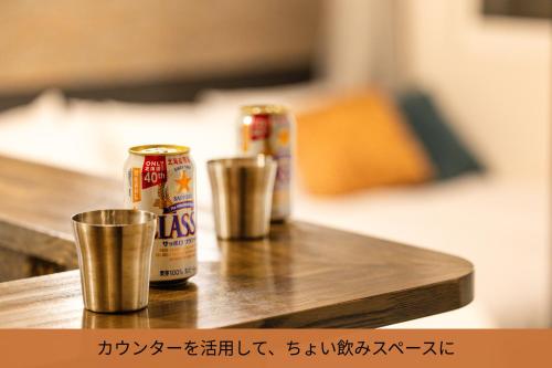 two cans of beer sitting on a wooden table at サンコート円山ガーデンヒルズ in Sapporo