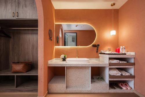 a bathroom with a sink and a mirror at Riverside Bamboo Frest Hotel in Xingping