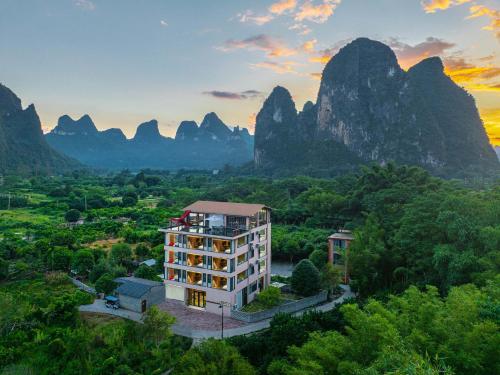 an aerial view of a hotel with mountains in the background at Riverside Bamboo Frest Hotel in Xingping
