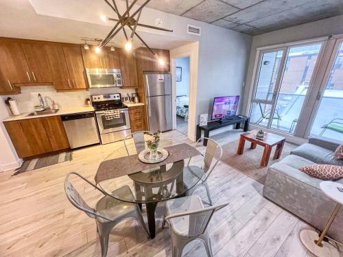 Una cocina y una sala de estar con mesa y sillas. en Downtown Elite Residences, en Montreal