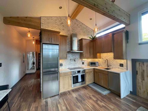 a kitchen with wooden cabinets and stainless steel appliances at Blue Owl - Tree House Views! Couples Getaway! in Idaho Springs