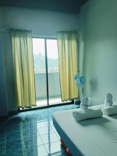 a bedroom with a bed and a large window at Your Own Room at a Shared Apartment with Balcony in Baguio