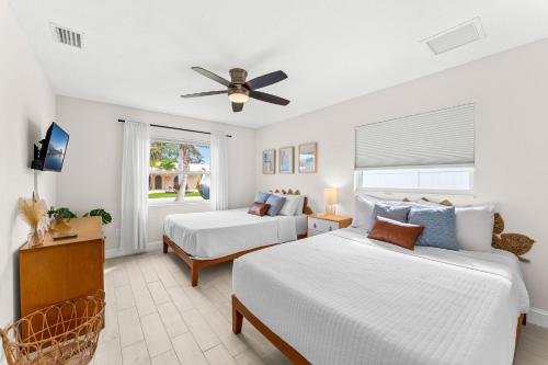 a bedroom with two beds and a ceiling fan at 368 Carmine Dr in Cocoa Beach
