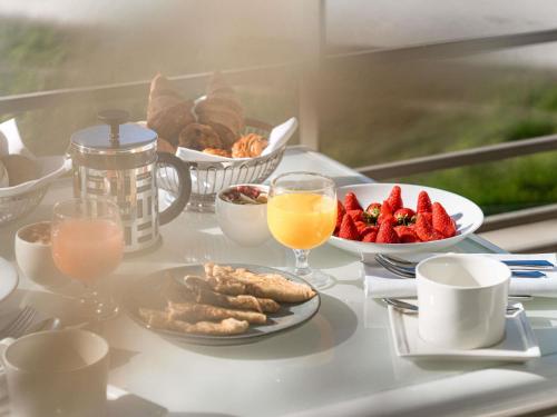Una mesa cubierta con platos de comida y bebidas. en Sofitel Quiberon Thalassa sea & spa, en Quiberon