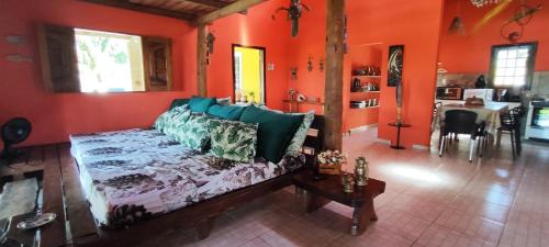 a living room with orange walls and a couch at Villa da Apa in Japaratinga