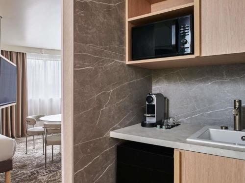una cocina con fregadero y microondas en Novotel Paris 13 Porte d'Italie, en Le Kremlin-Bicêtre