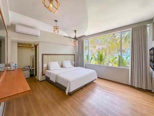 a bedroom with a white bed and a large window at White Sand in Himandhoo 