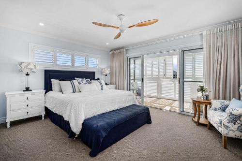 a bedroom with a bed and a ceiling fan at Lambent - Casuarina House in Casuarina