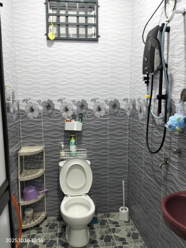a small bathroom with a toilet and a shower at Bait al-Qamar in Kampong Wakaf Tengah
