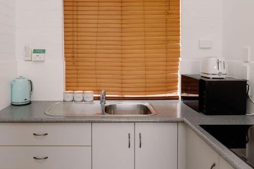 a kitchen counter with a sink and a microwave at Elysian Hills in Carool