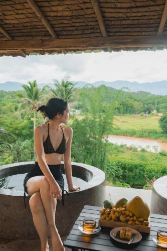 a woman in a bathing suit sitting in a bath tub at Puripai Villa in Pai