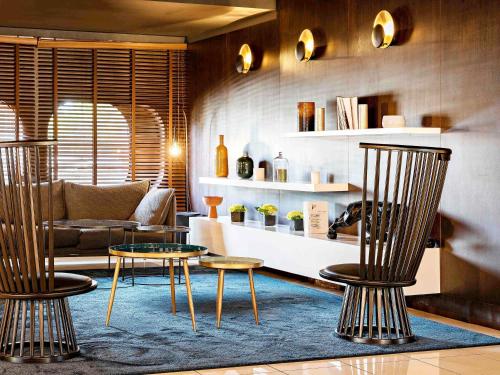 een woonkamer met twee stoelen en een tafel bij Pullman Bordeaux Lac in Bordeaux